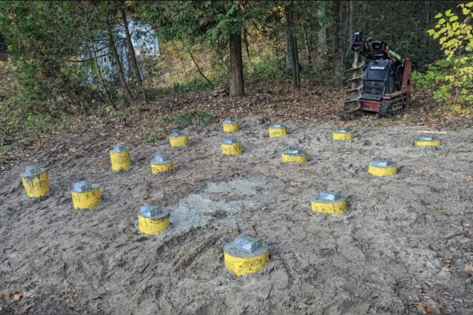 Deck footing forms and compact auger equipment on a Done Well Post Holes job site